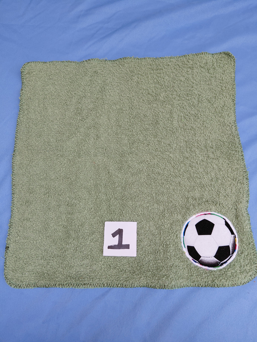 Green washcloth with an embellished soccer ball 