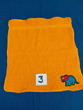 Orange washcloth embellished with a dinosaur design